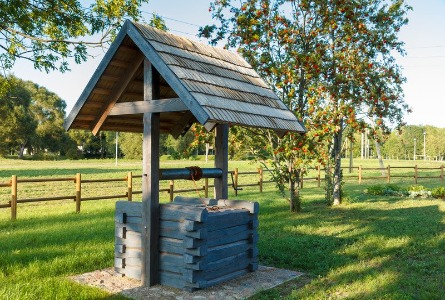 Retro wooden water well in a countryside