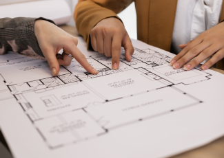 two hands pointing at items on a planning drawing