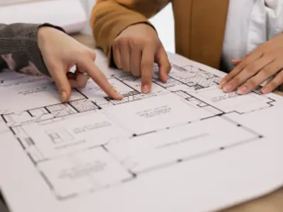 two hands pointing at items on a planning drawing
