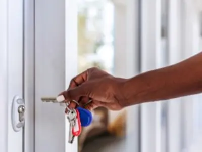 a hand with keys unlocking a storefront